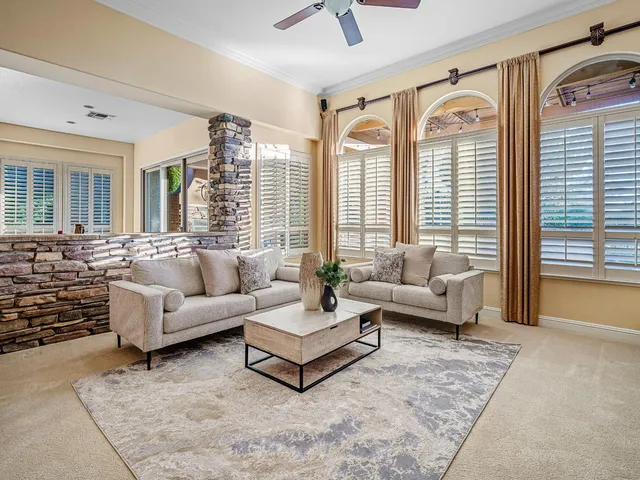 a dining room with furniture a chandelier and wooden floor