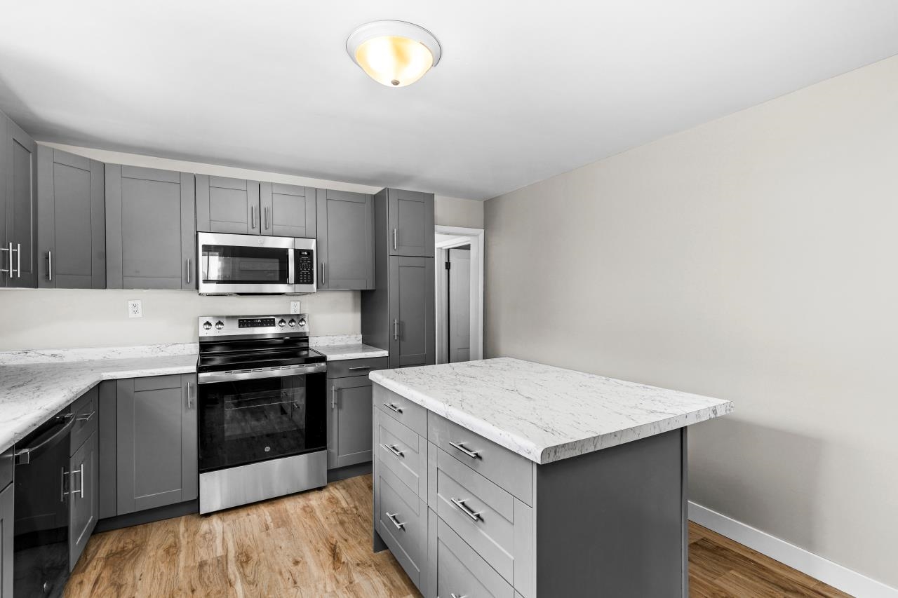 310 3rd Street Cloquet, MN 55720 - Photo 22 of 39 Kitchen featuring gray cabinetry, stainless steel appliances, a kitchen island, and light wood-style floors