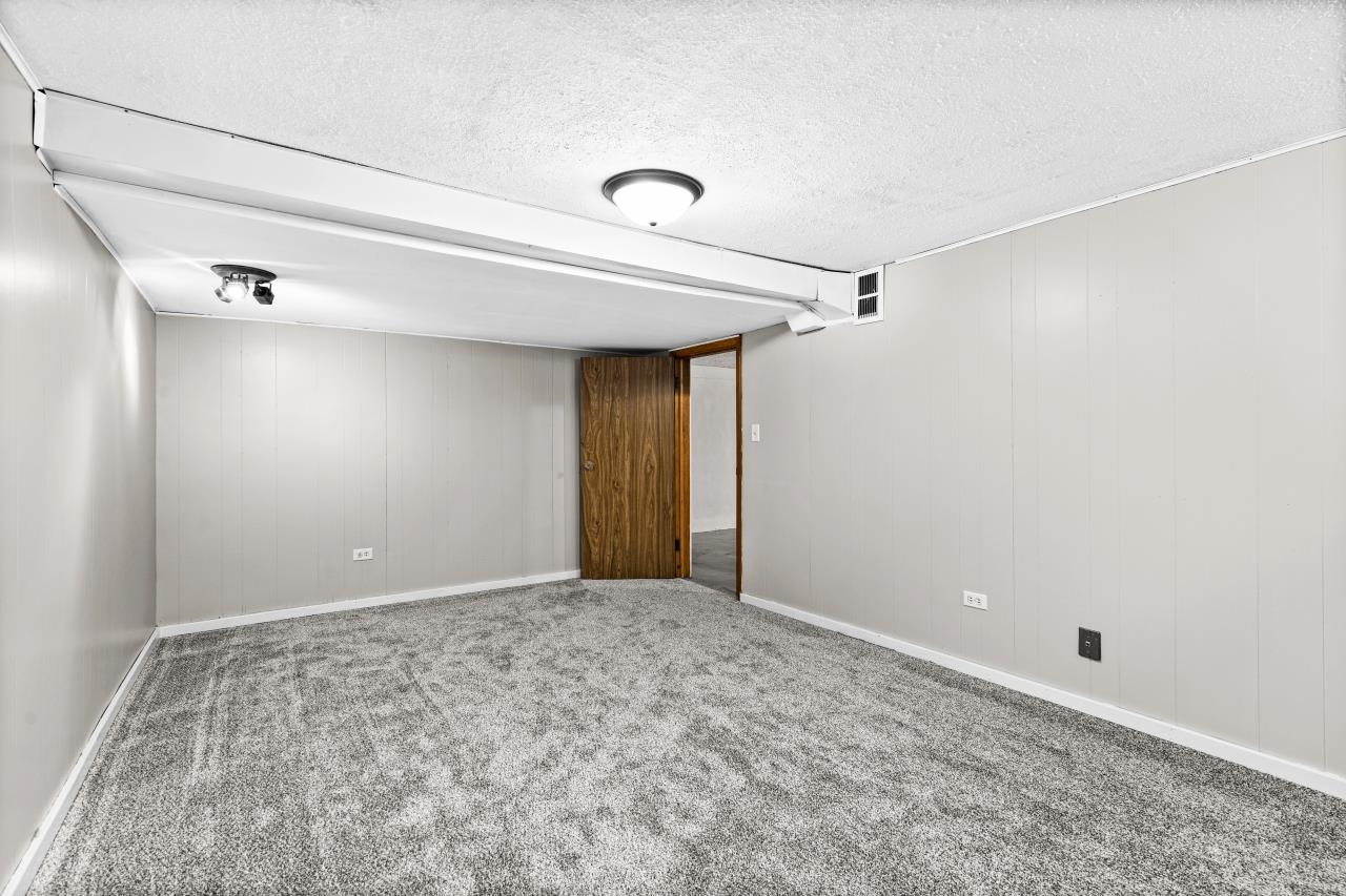 310 3rd Street Cloquet, MN 55720 - Photo 26 of 39 Carpeted spare room featuring wood walls and a textured ceiling