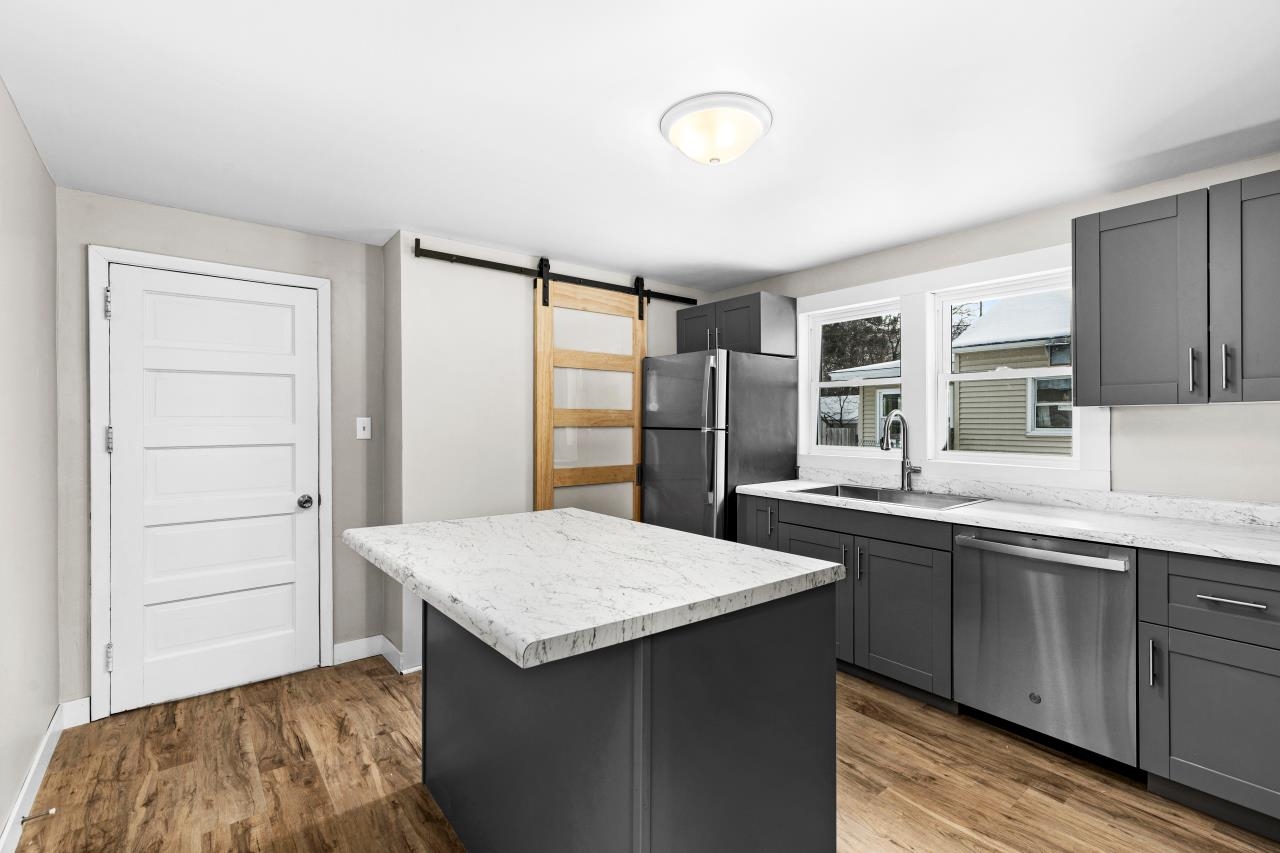 310 3rd Street Cloquet, MN 55720 - Photo 3 of 39 Kitchen featuring a barn door, gray cabinets, and stainless steel appliances