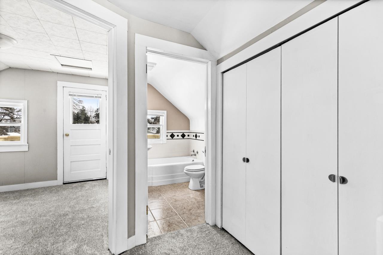 310 3rd Street Cloquet, MN 55720 - Photo 31 of 39 Full bath featuring lofted ceiling, light carpet, light tile patterned floors, a bath, and a closet