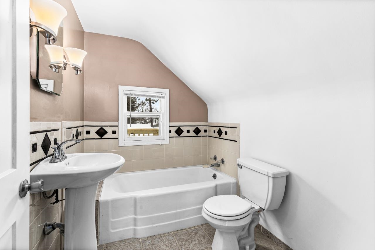 310 3rd Street Cloquet, MN 55720 - Photo 33 of 39 Bathroom featuring a garden tub, vaulted ceiling, and light tile patterned flooring