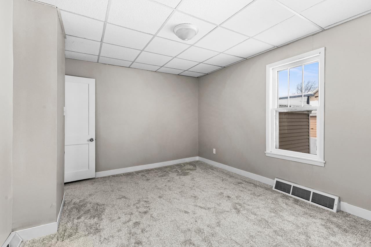 310 3rd Street Cloquet, MN 55720 - Photo 7 of 39 Unfurnished room featuring a paneled ceiling and light colored carpet