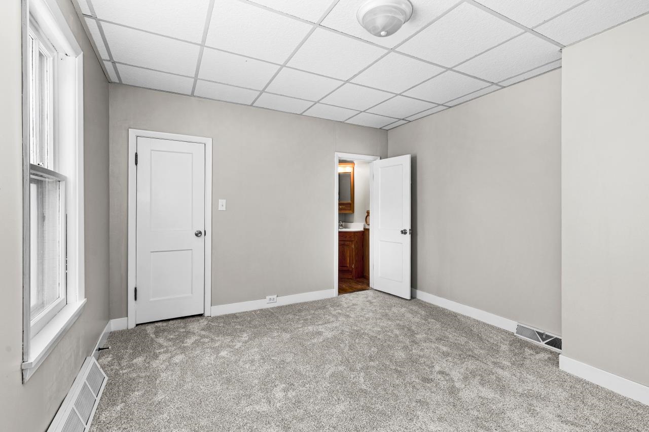 310 3rd Street Cloquet, MN 55720 - Photo 8 of 39 Unfurnished bedroom featuring a drop ceiling, carpet flooring, and multiple windows