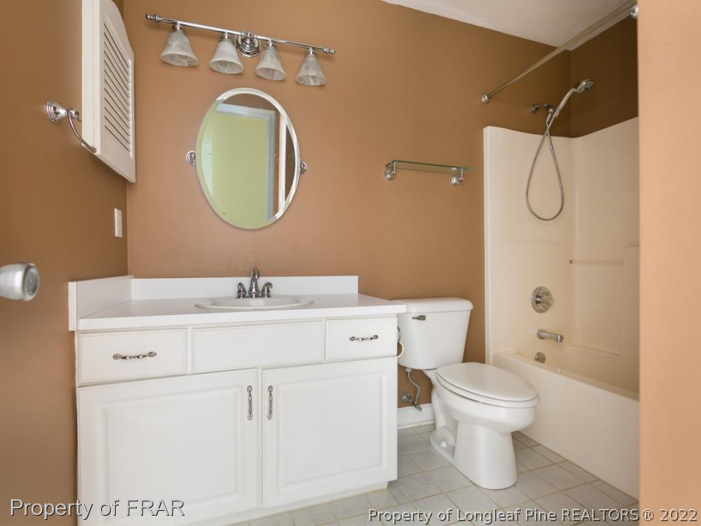 218 Larchmont Road Fayetteville, NC 28311 - Photo 19 of 28 a bathroom with a toilet sink vanity and mirror