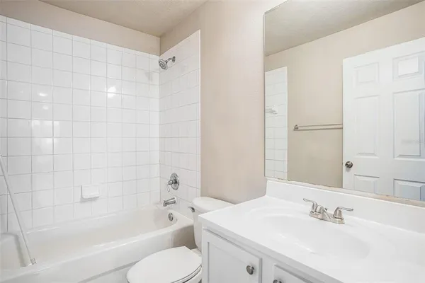 a bathroom with a bathtub shower sink vanity and toilet