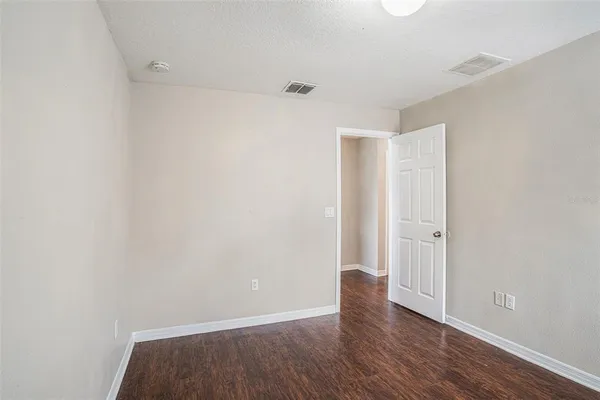 a view of an empty room with wooden floor