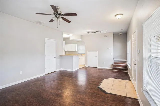 a view of an empty room and wooden floor and a window