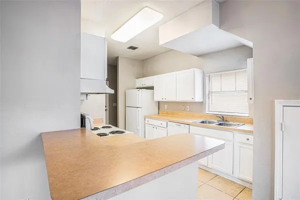 a kitchen with kitchen island a stove a sink and a refrigerator