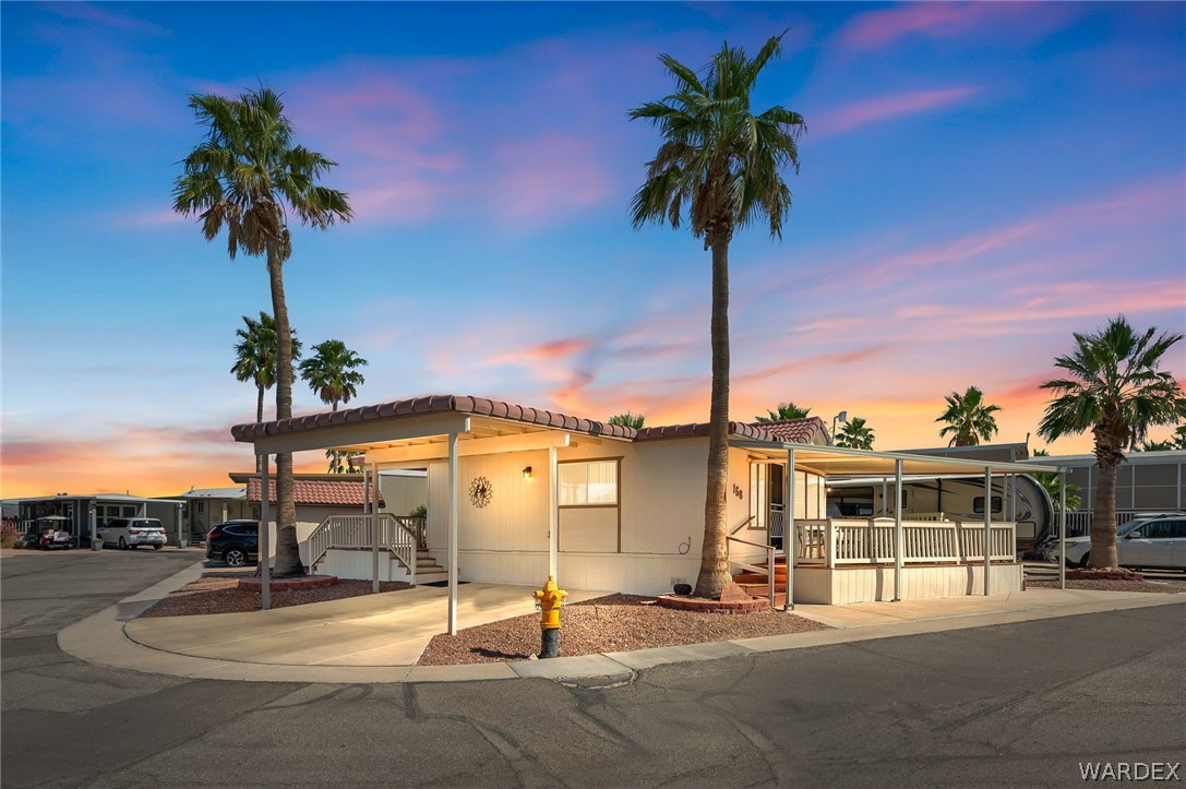 2000 Ramar Road, Unit 158 Bullhead City, AZ 86442 - Photo 2 of 78 Stunning corner lot park model with swaying palms and glowing sunset skies? curb appeal that instantly sets this home apart in Riverview RV Resort.