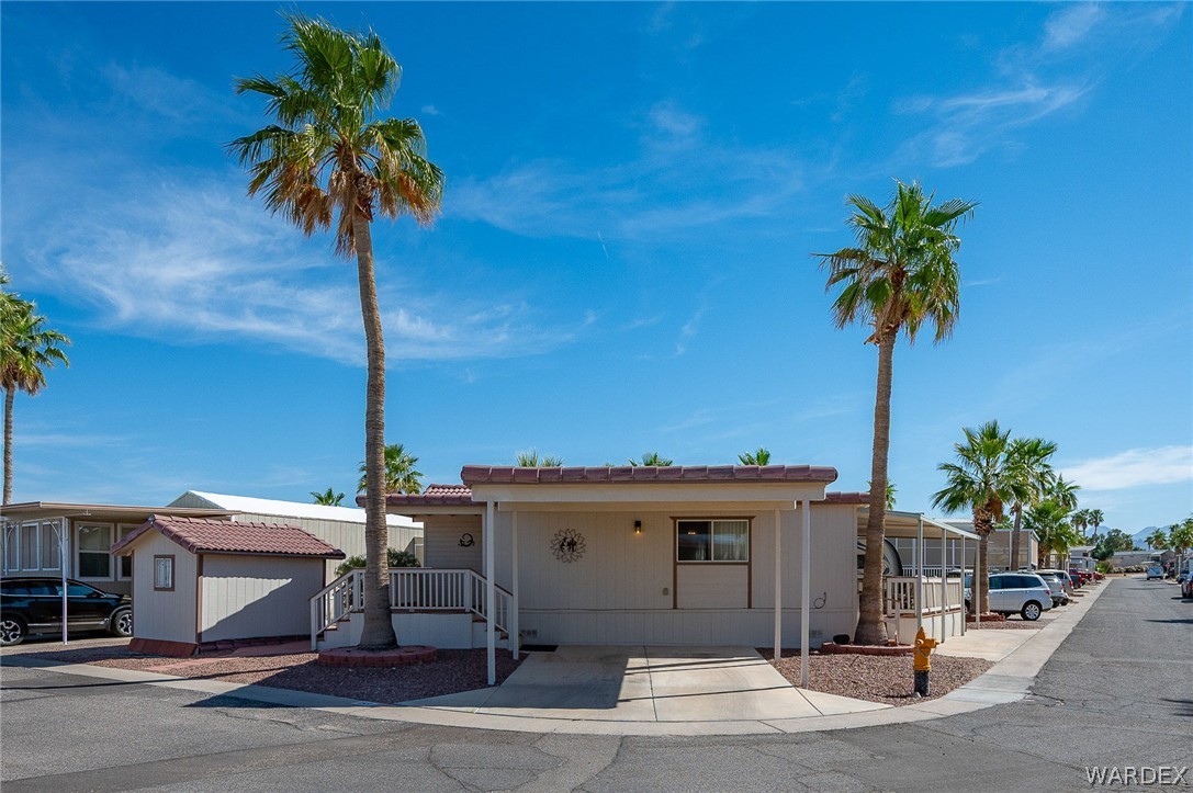 2000 Ramar Road, Unit 158 Bullhead City, AZ 86442 - Photo 7 of 78 Clean front elevation on a desirable corner lot? featuring covered parking, tile roof, and low-maintenance desert landscaping with mature palms.