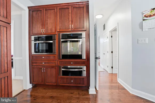 a view of kitchen with stainless steel appliances granite countertop cabinets and a wooden floor
