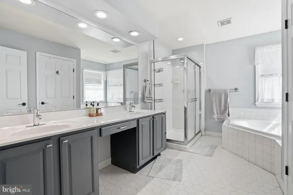 a spacious bathroom with a bathtub shower sink double and mirror