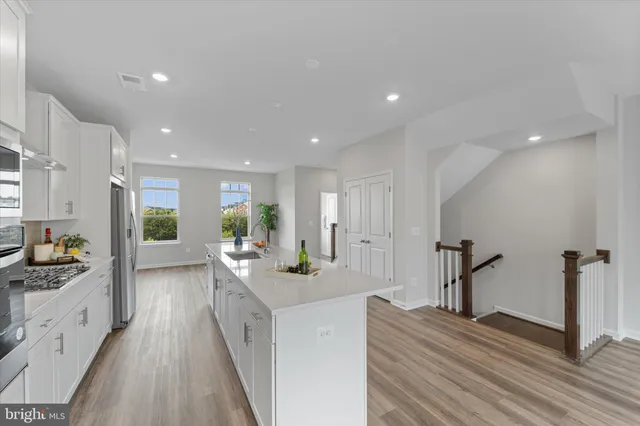 a large white kitchen with sink and refrigerator
