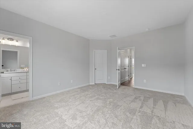 a view of an empty room with window and bathroom