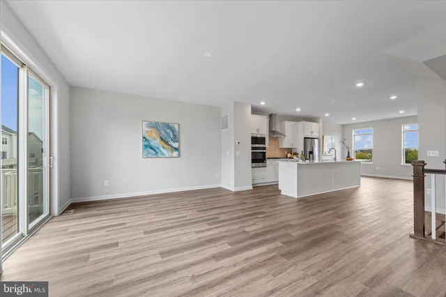 a view of kitchen with kitchen island wooden floor and window