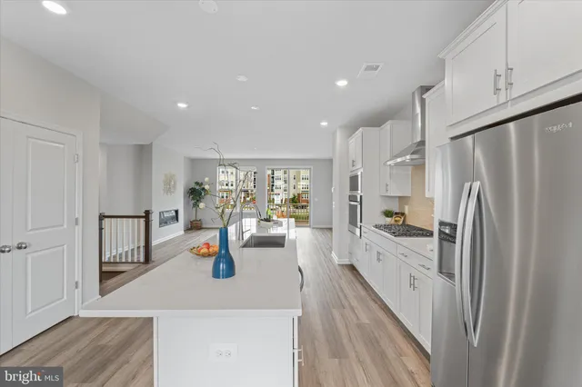 a kitchen with stainless steel appliances a refrigerator sink and cabinets