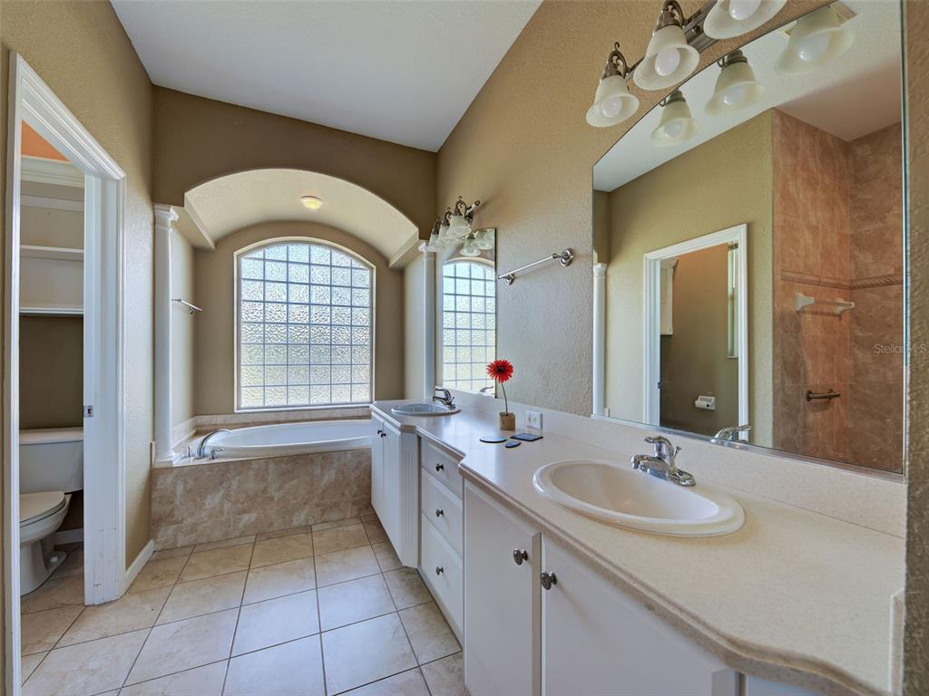 45 Tee View Road Rotonda West, FL 33947 - Photo 18 of 64 a spacious bathroom with a granite countertop sink a large mirror and a bathtub