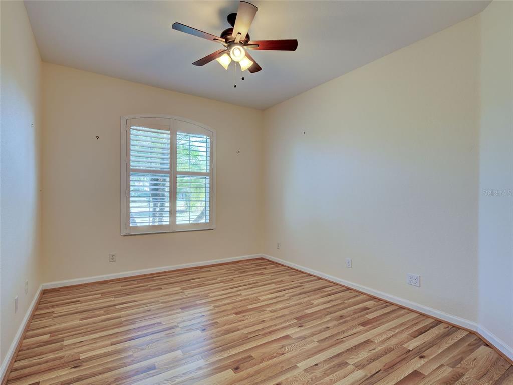 45 Tee View Road Rotonda West, FL 33947 - Photo 21 of 64 wooden floor in an empty room with a window