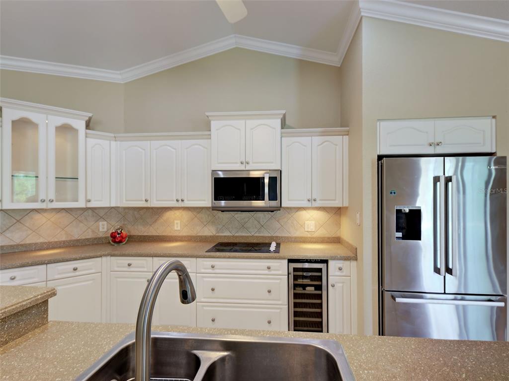 45 Tee View Road Rotonda West, FL 33947 - Photo 26 of 64 a kitchen with refrigerator a microwave a stove and cabinets