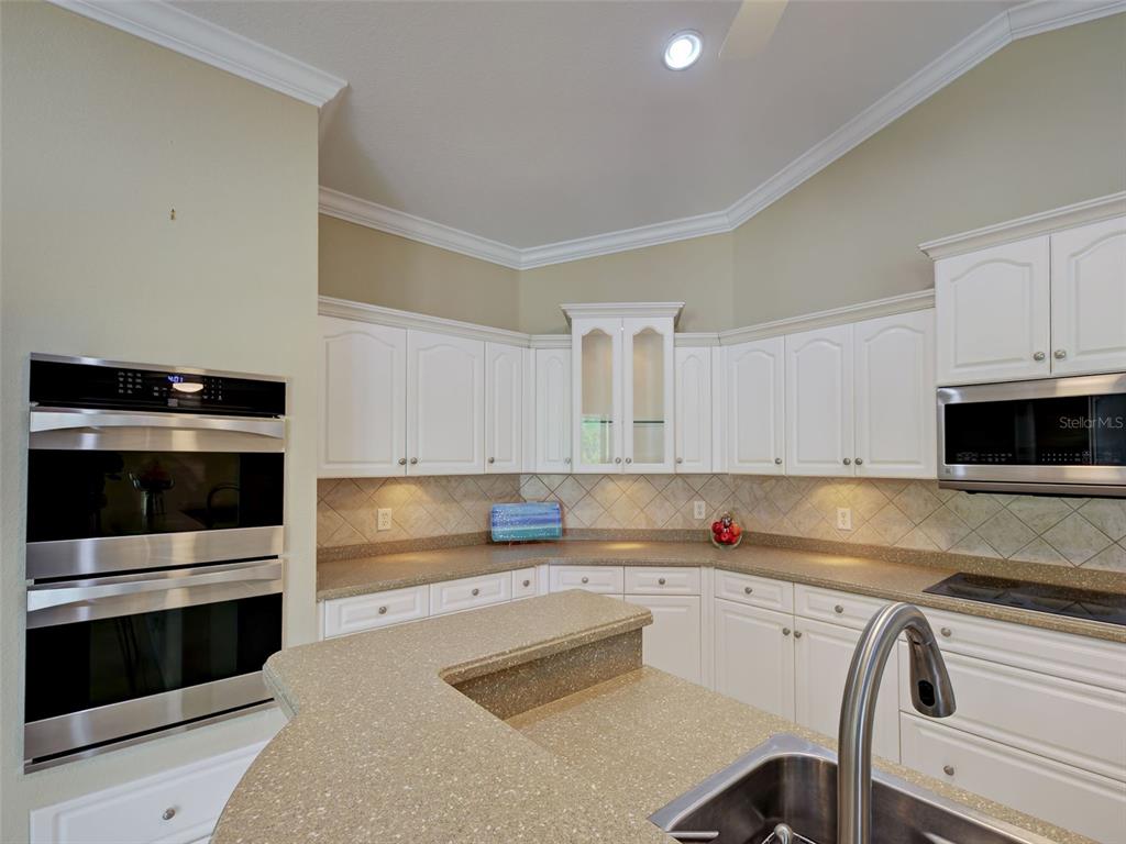 45 Tee View Road Rotonda West, FL 33947 - Photo 27 of 64 a kitchen with granite countertop white cabinets and stainless steel appliances