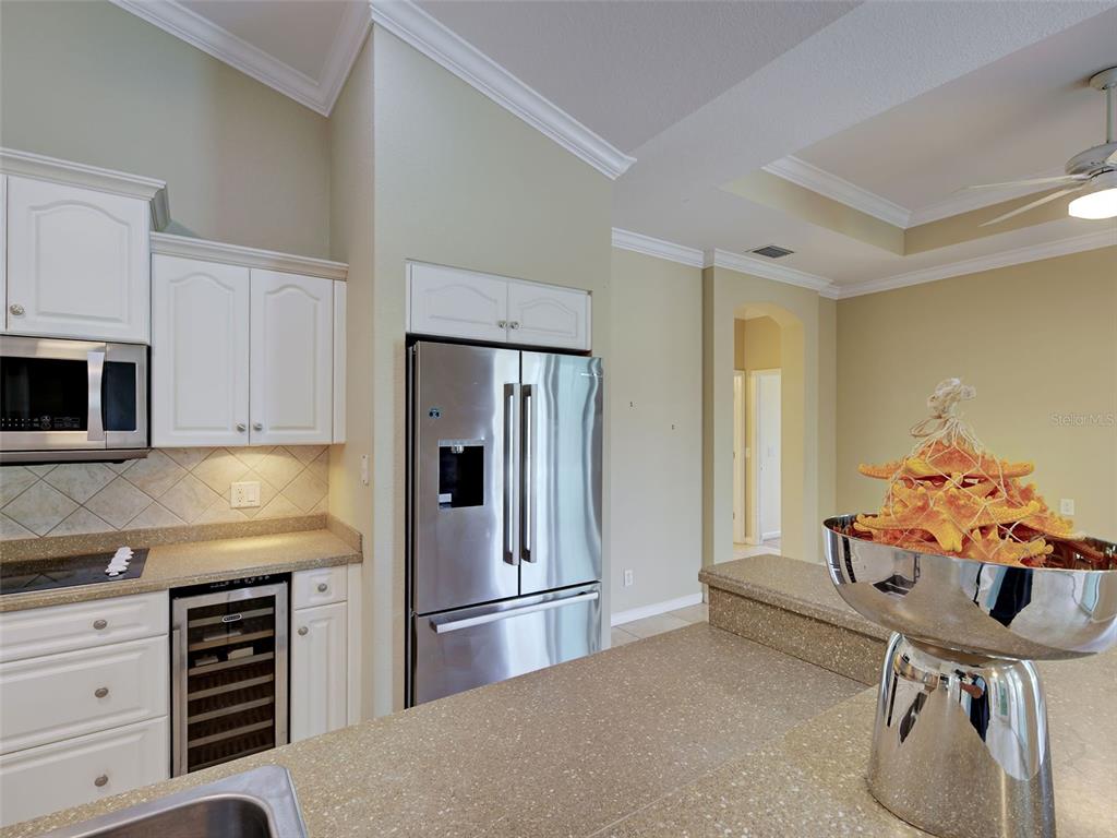 45 Tee View Road Rotonda West, FL 33947 - Photo 28 of 64 a kitchen with stainless steel appliances kitchen island a refrigerator sink and cabinets