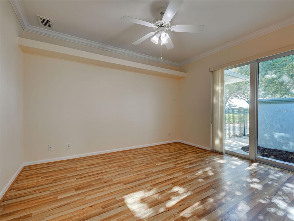45 Tee View Road Rotonda West, FL 33947 - Photo 34 of 64 en empty room with wooden floor and fan