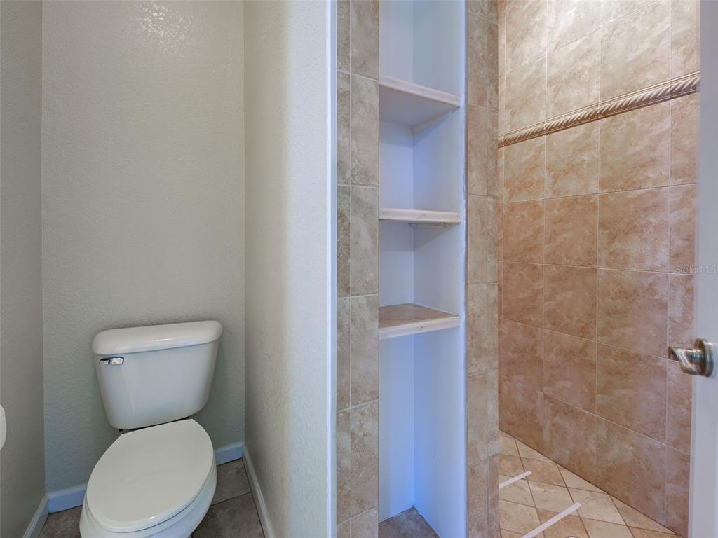 45 Tee View Road Rotonda West, FL 33947 - Photo 47 of 64 a white toilet sitting next to a bathroom sink