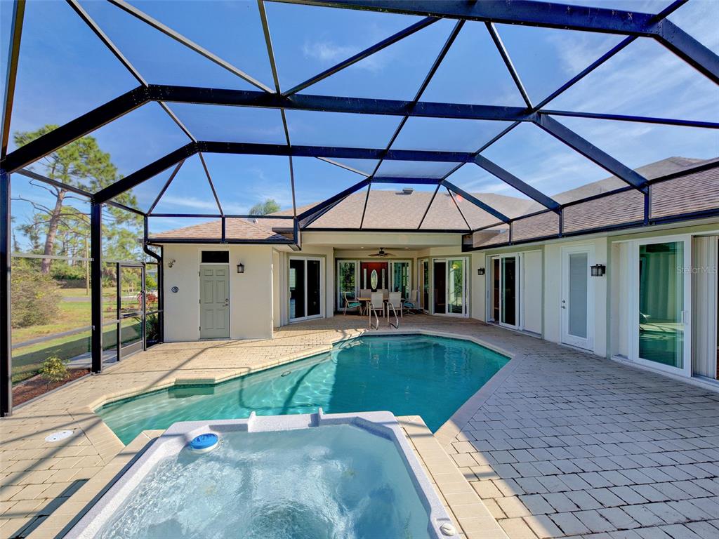 45 Tee View Road Rotonda West, FL 33947 - Photo 53 of 64 a view of a patio with a table and chairs under an umbrella
