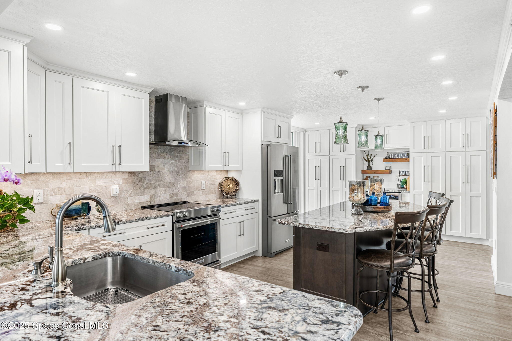 407 Florida A1A, Unit 464 Satellite Beach, FL 32937 - Photo 11 of 38 a kitchen with stainless steel appliances kitchen island granite countertop a sink stove and refrigerator