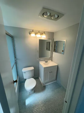 a bathroom with a toilet sink and mirror