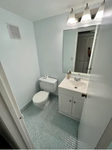 a bathroom with a sink a toilet and mirror