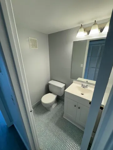 a bathroom with a sink mirror and toilet