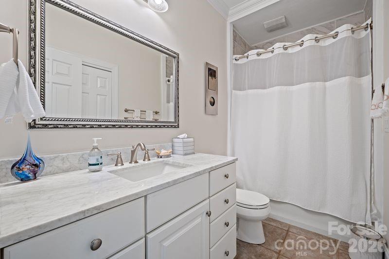 17426 Springwinds Drive, Unit 122 Cornelius, NC 28031 - Photo 12 of 36 a bathroom with a granite countertop sink a toilet and a mirror
