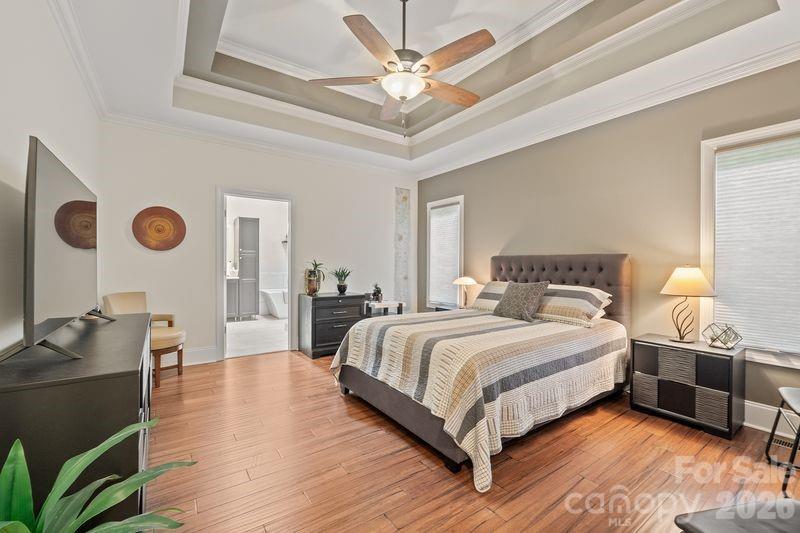 17426 Springwinds Drive, Unit 122 Cornelius, NC 28031 - Photo 18 of 36 a bedroom with a bed and dresser with wooden floor