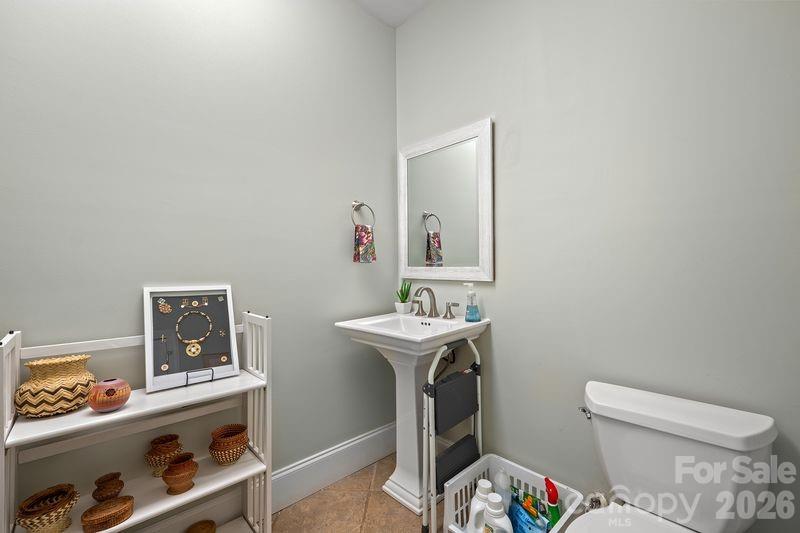 17426 Springwinds Drive, Unit 122 Cornelius, NC 28031 - Photo 24 of 36 a bathroom with a toilet a sink and mirror