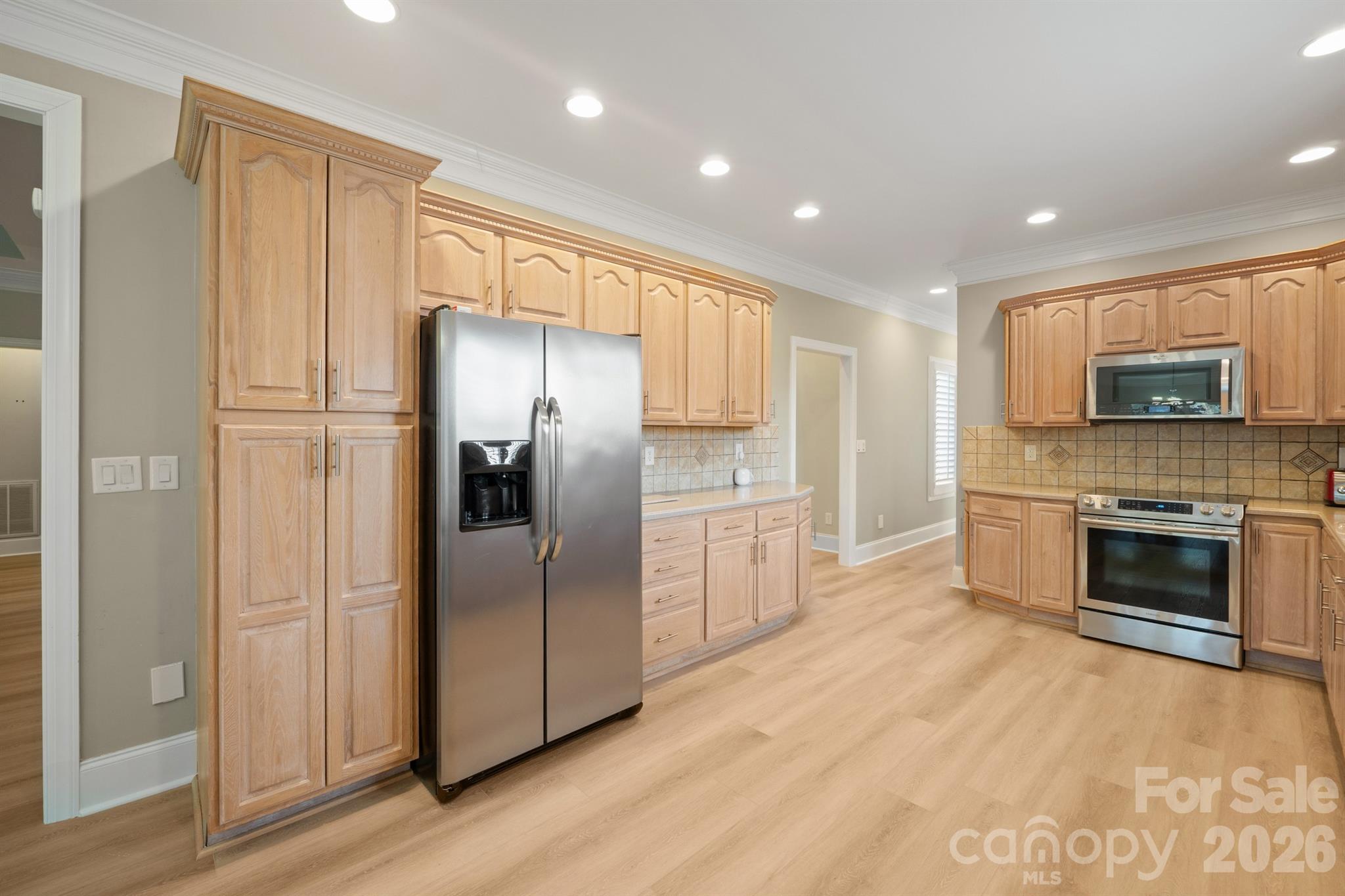 17426 Springwinds Drive, Unit 122 Cornelius, NC 28031 - Photo 35 of 36 a kitchen with a refrigerator and a stove top oven