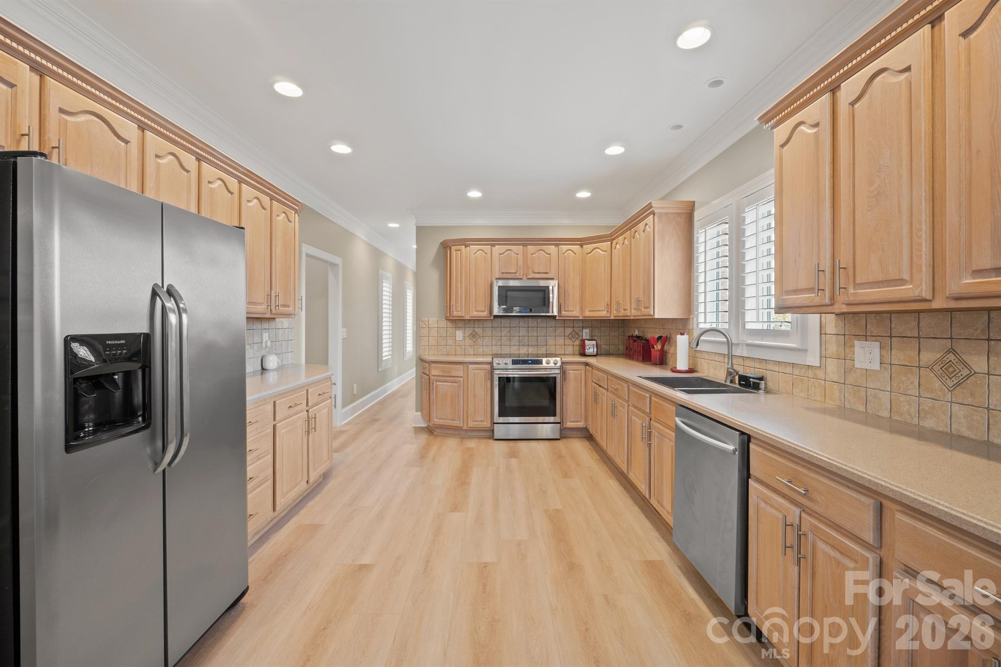 17426 Springwinds Drive, Unit 122 Cornelius, NC 28031 - Photo 36 of 36 a large kitchen with stainless steel appliances granite countertop a refrigerator a sink dishwasher a oven with white cabinets and wooden floor