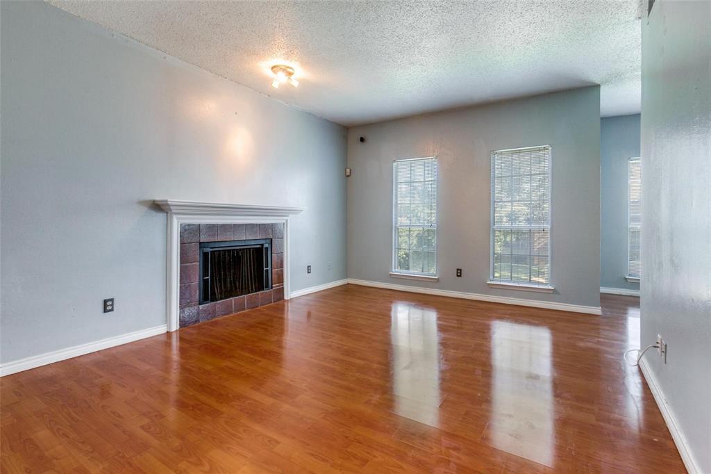 8600 Coppertowne Lane, Unit 1507 Dallas, TX 75243 - Photo 2 of 20 a view of empty room with wooden floor and fireplace