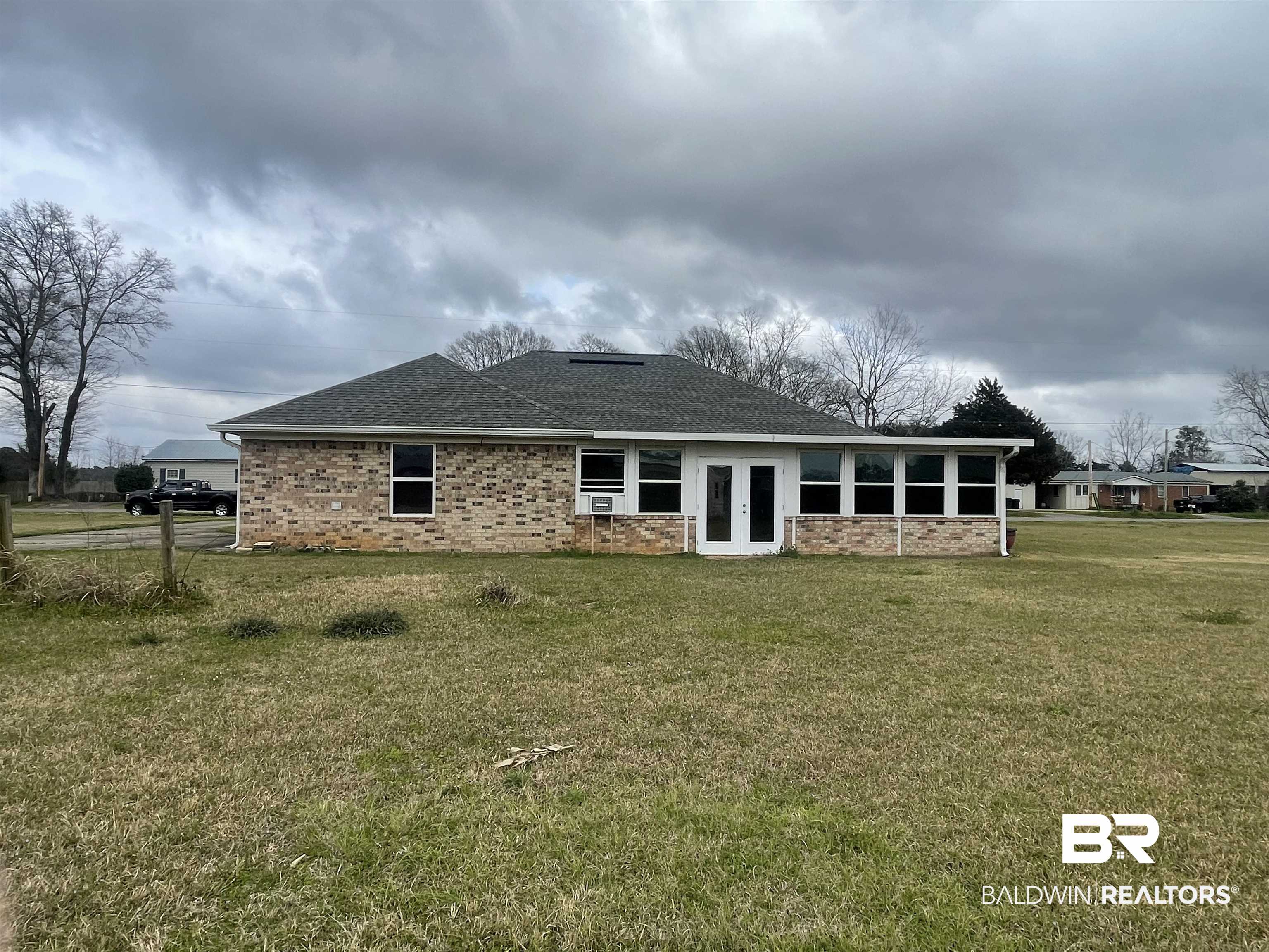 23575 Fountain Street Robertsdale, AL 36567 - Photo 13 of 19 Back of house featuring a shingled roof, french doors, brick siding, and a yard