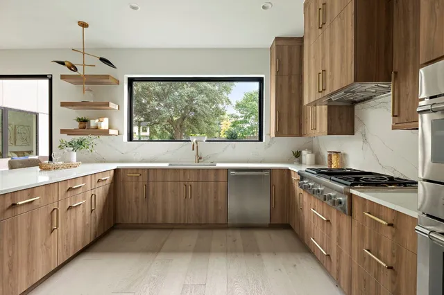 a kitchen with stainless steel appliances granite countertop a stove a sink and a refrigerator