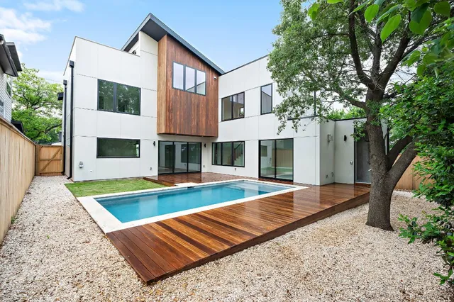 a view of a house with pool and chairs