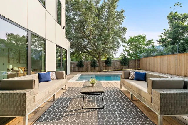 a view of a swimming pool with table and chairs under an umbrella