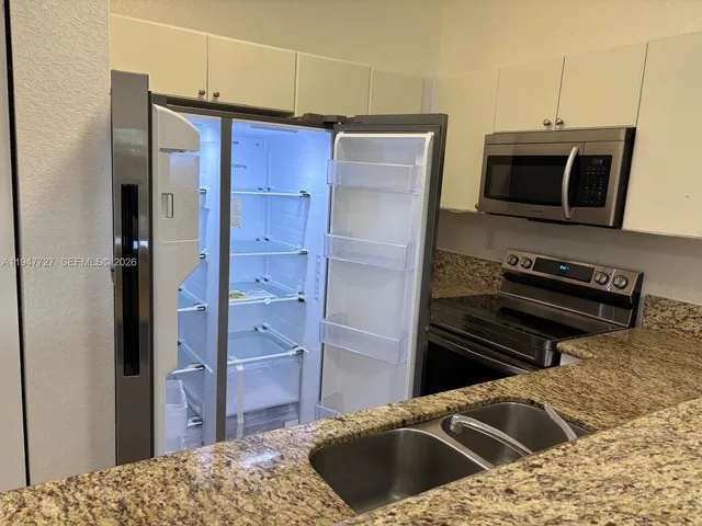 a kitchen with a refrigerator and a sink