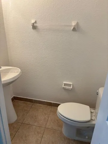 a white toilet sitting next to a shower