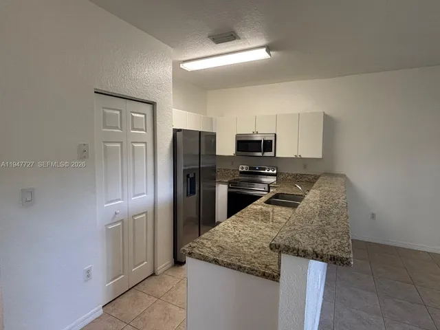 a kitchen with granite countertop cabinets and stainless steel appliances