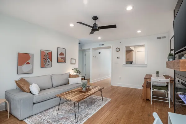 a living room with furniture and a wooden floor