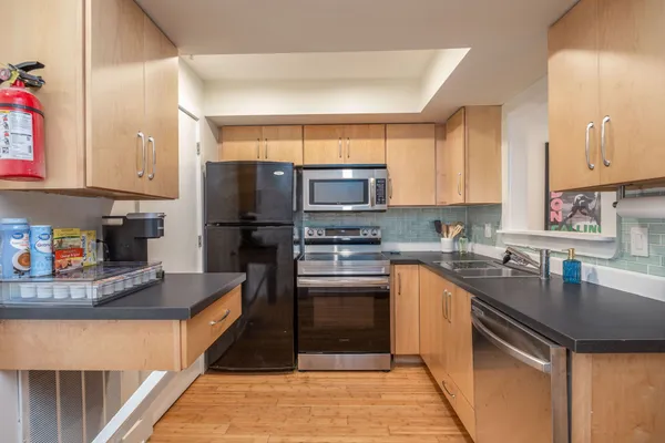 a kitchen with stainless steel appliances granite countertop a refrigerator sink and stove