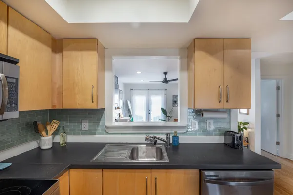 a kitchen with granite countertop a sink a stove and cabinets