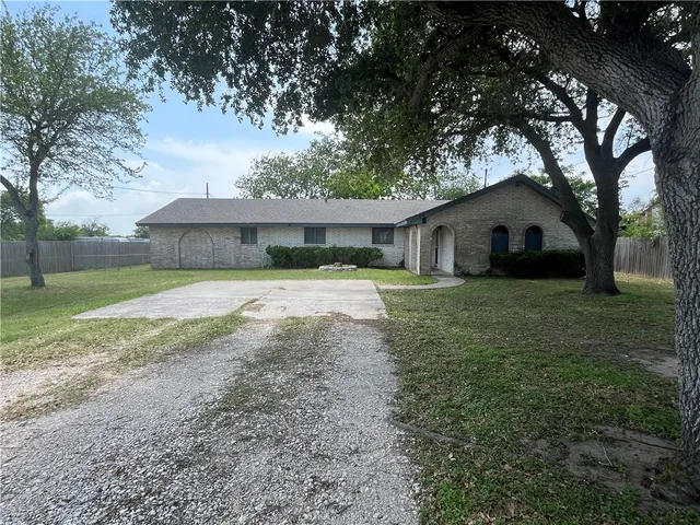 a front view of a house with a yard and trees